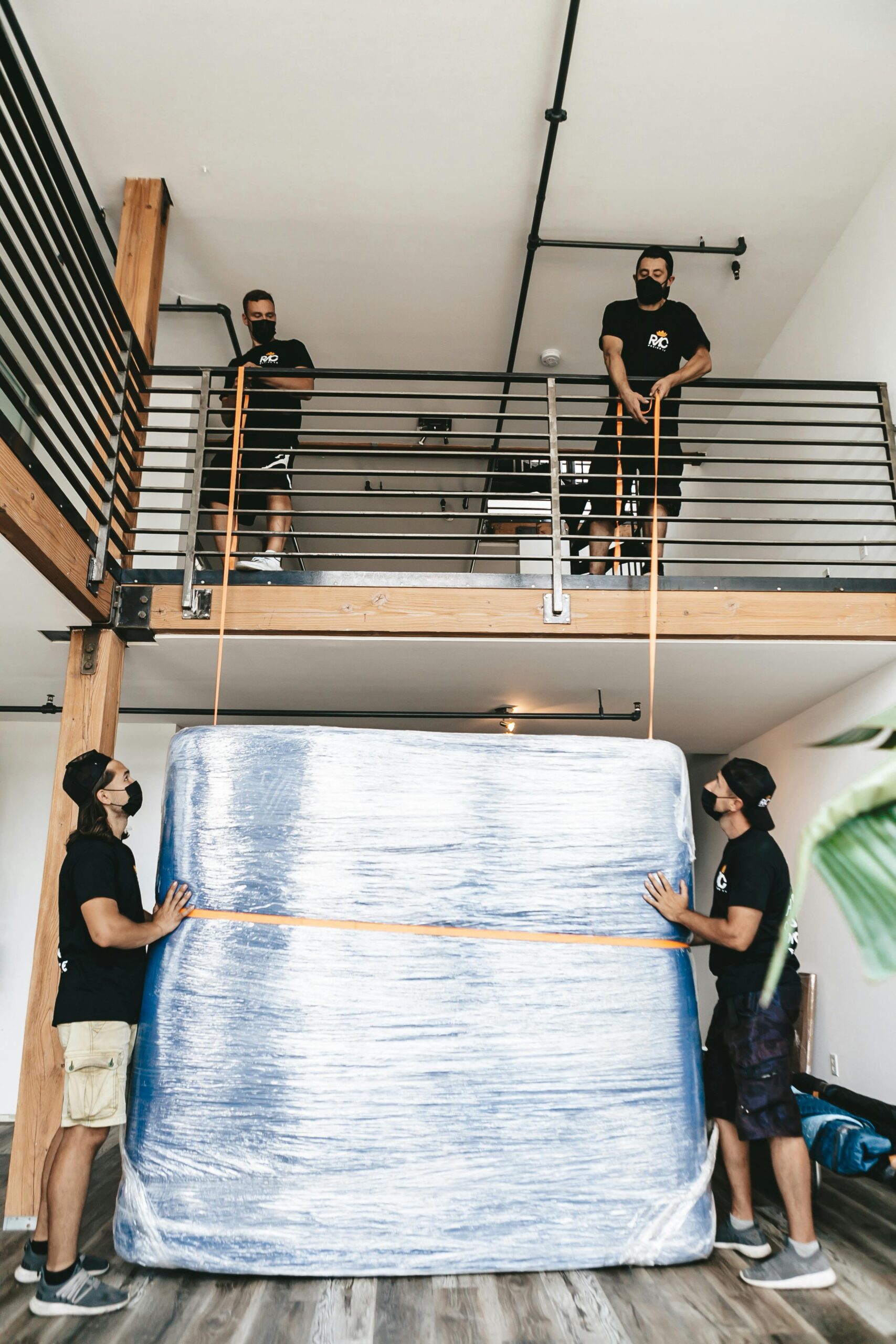 Professional movers carefully packing and lifting a furniture item